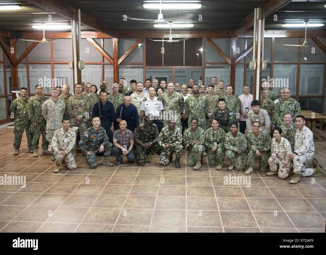 Attendees gather for a group photo at a cultural exchange event led by Japan Ground Self-Defense Force leadership at Camp Lemonnier, Djibouti, Nov. 28, 2018. Multinational military partners affiliated with Camp Lemonnier hold monthly exchange events to strengthen alliances and attract new partners in the combined joint military environment. Stock Photo