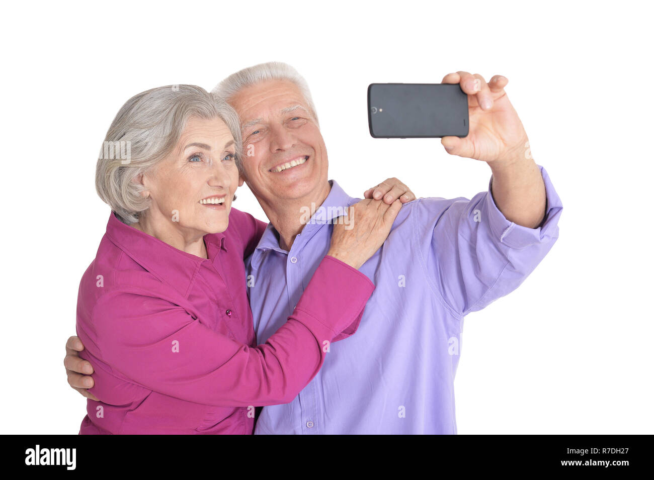 Portrait of a happy senior couple taking selfie photo on white background Stock Photo