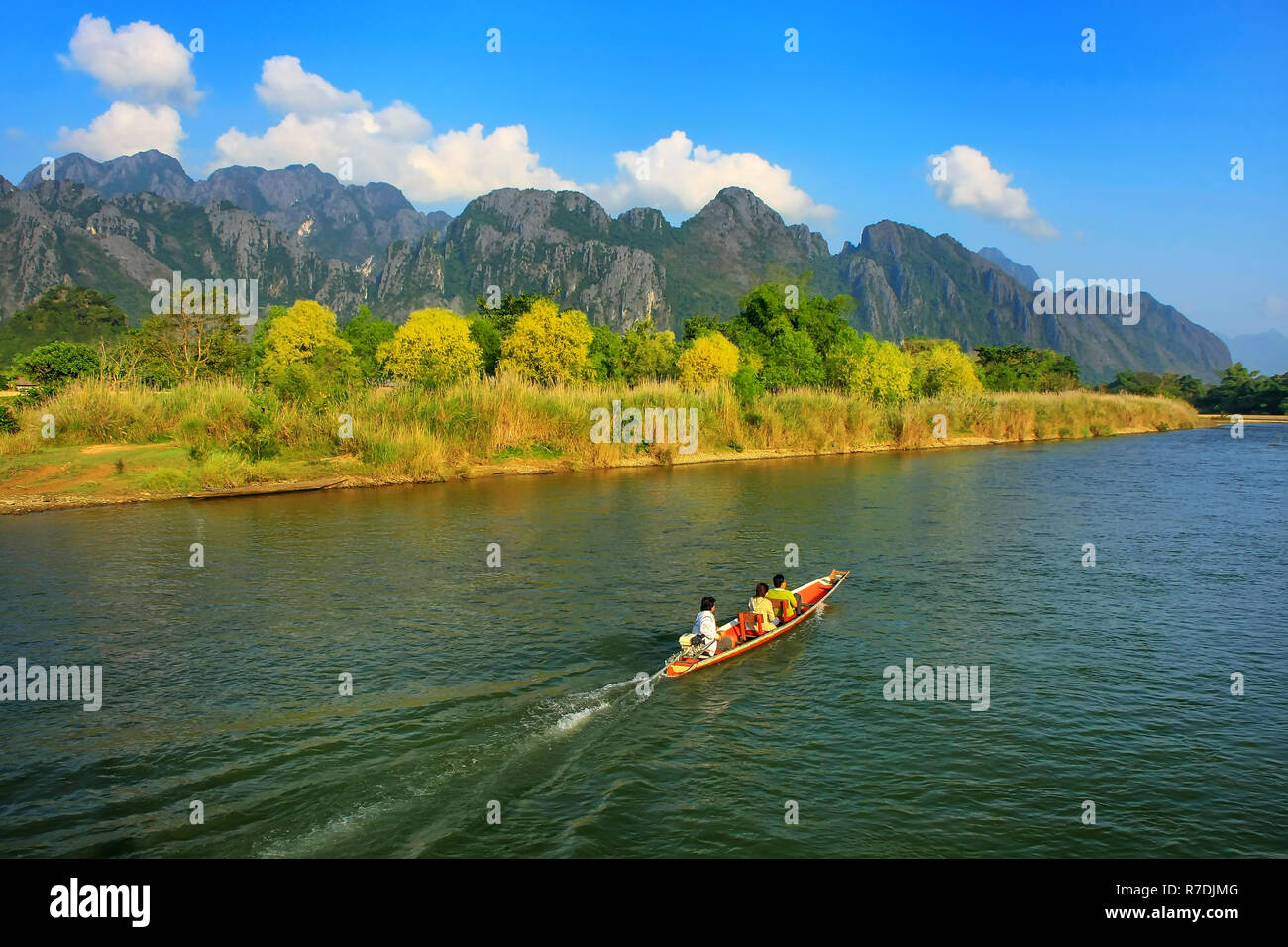 Motorboat moving on Nam Song River in Vang Vieng, Laos. Vang Vieng is a popular destination for adventure tourism in a limestone karst landscape. Stock Photo