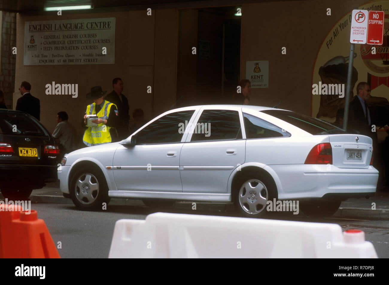 PARKING INSPECTOR OR BROWN BOMBER AS THEY ARE KNOWN IN AUSTRALIA, ISSUING A PARKING TICKET, SYDNEY, NSW, AUSTRALIA Stock Photo