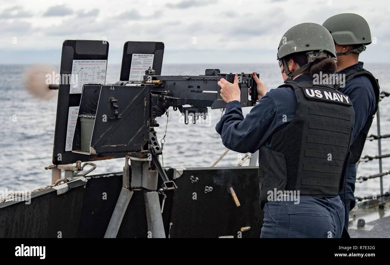 WATERS SOUTH OF JAPAN (May 17, 2017) Chief Gunner’s Mate Laura Needham fires a .50 caliber machine gun during live-fire exercise aboard the Arleigh Burke-class guided-missile destroyer USS McCampbell (DDG 85). The ship is on patrol in the U.S. 7th Fleet area of operations in support of security and stability in the Indo-Asia-Pacific region. Stock Photo