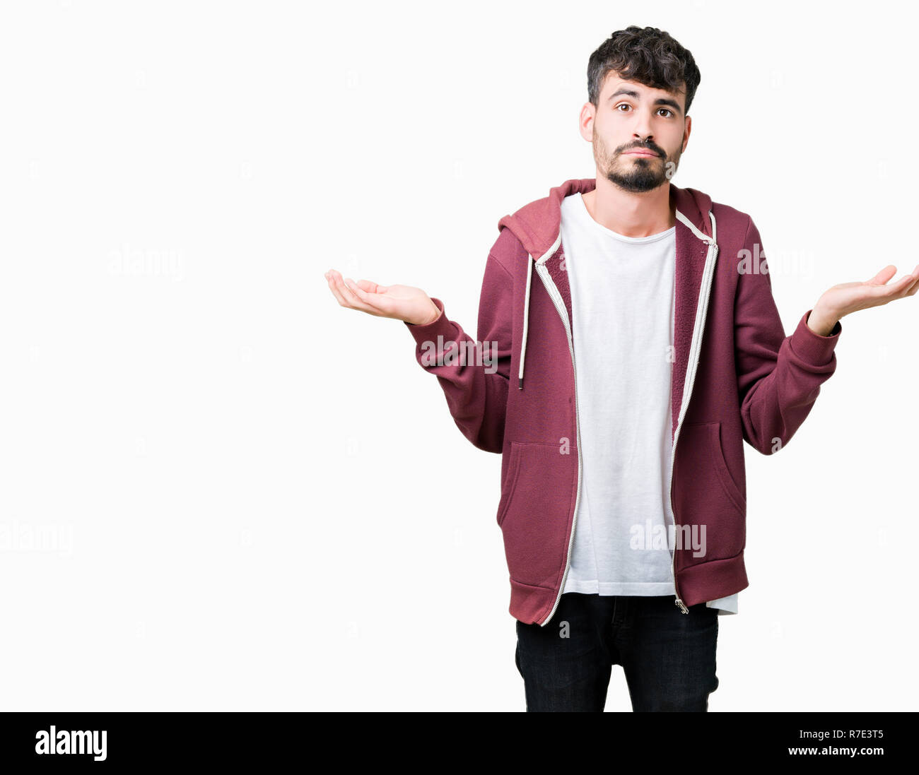 Young handsome man over isolated background clueless and confused expression with arms and hands raised. Doubt concept. Stock Photo