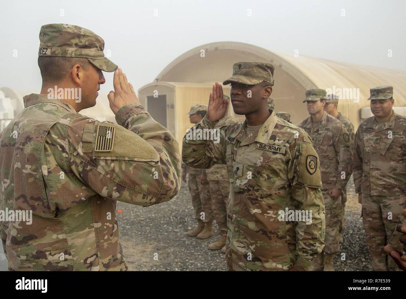 Spc. Andrew Miller salutes Capt. Diego Hernandez, Company Commander, for the last time as a Spc during his promotion ceremony to Sgt on Dec. 01, 2018, Camp Arifjan, Kuwait. Stock Photo