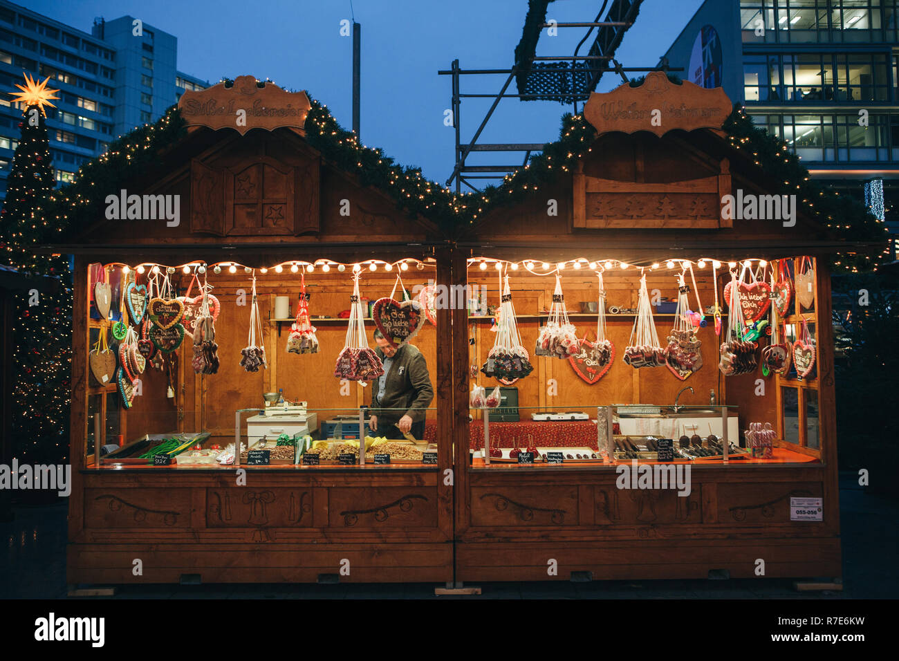 Berlin, December 25, 2017: Selling sweets and traditional gingerbread in the evening at the Christmas market in Berlin. Decorated stall. Stock Photo