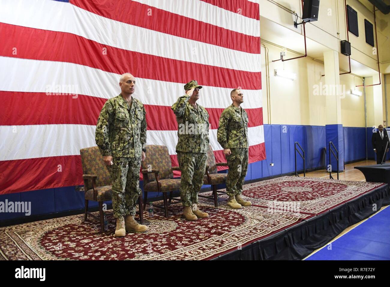 MANAMA, Bahrain (Dec. 5, 2018) Vice Chief of Naval Operations Adm. Bill Moran, center, salutes as “Taps” plays during a memorial service honoring Vice Adm. Scott Stearney’s life.  Stearney was formerly commander of U.S.  Naval Forces Central Command, U.S. 5th Fleet and Combined Maritime Forces. The U.S. 5th Fleet area of operations encompasses nearly 2.5 million square miles of water area and includes the Arabian Gulf, Gulf of Oman, Red Sea and parts of the Indian Ocean. The region is comprised of 20 countries and includes three critical choke points at the Strait of Hormuz, the Suez Canal and Stock Photo