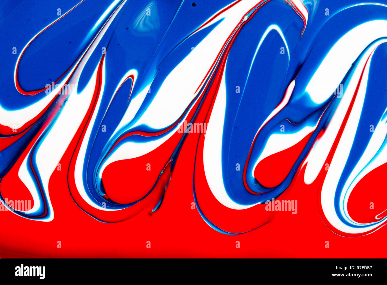 Colourful abstract background of red white and blue liquid paint swirls ...