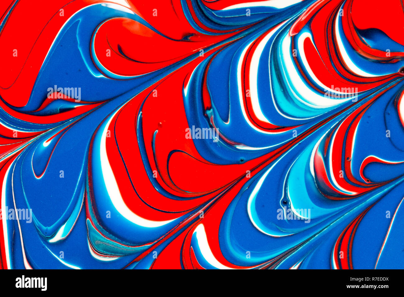Colourful abstract background of red white and blue liquid paint swirls ...