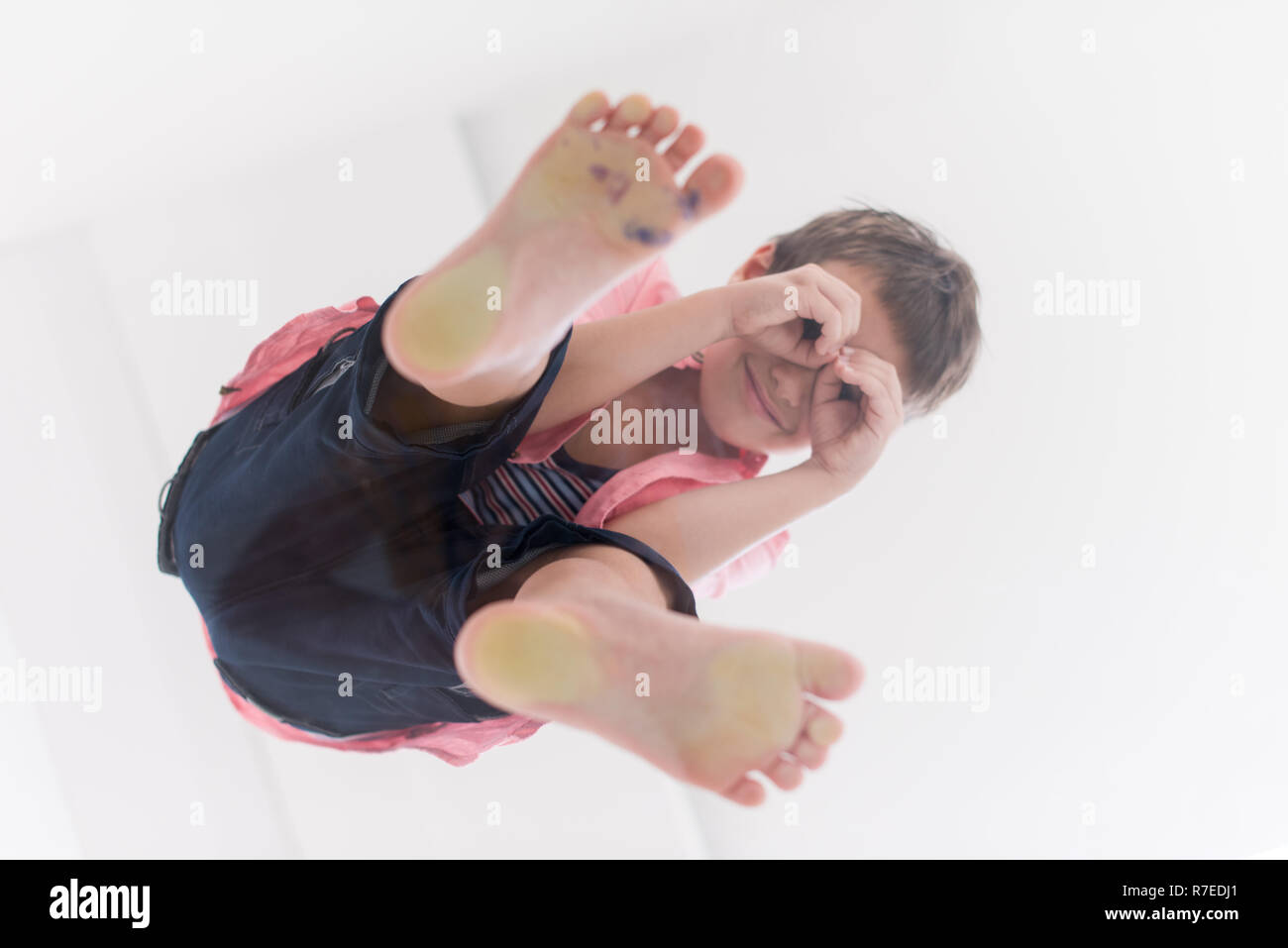 Under View down under view of a cute little boy standing on transparent glass ...