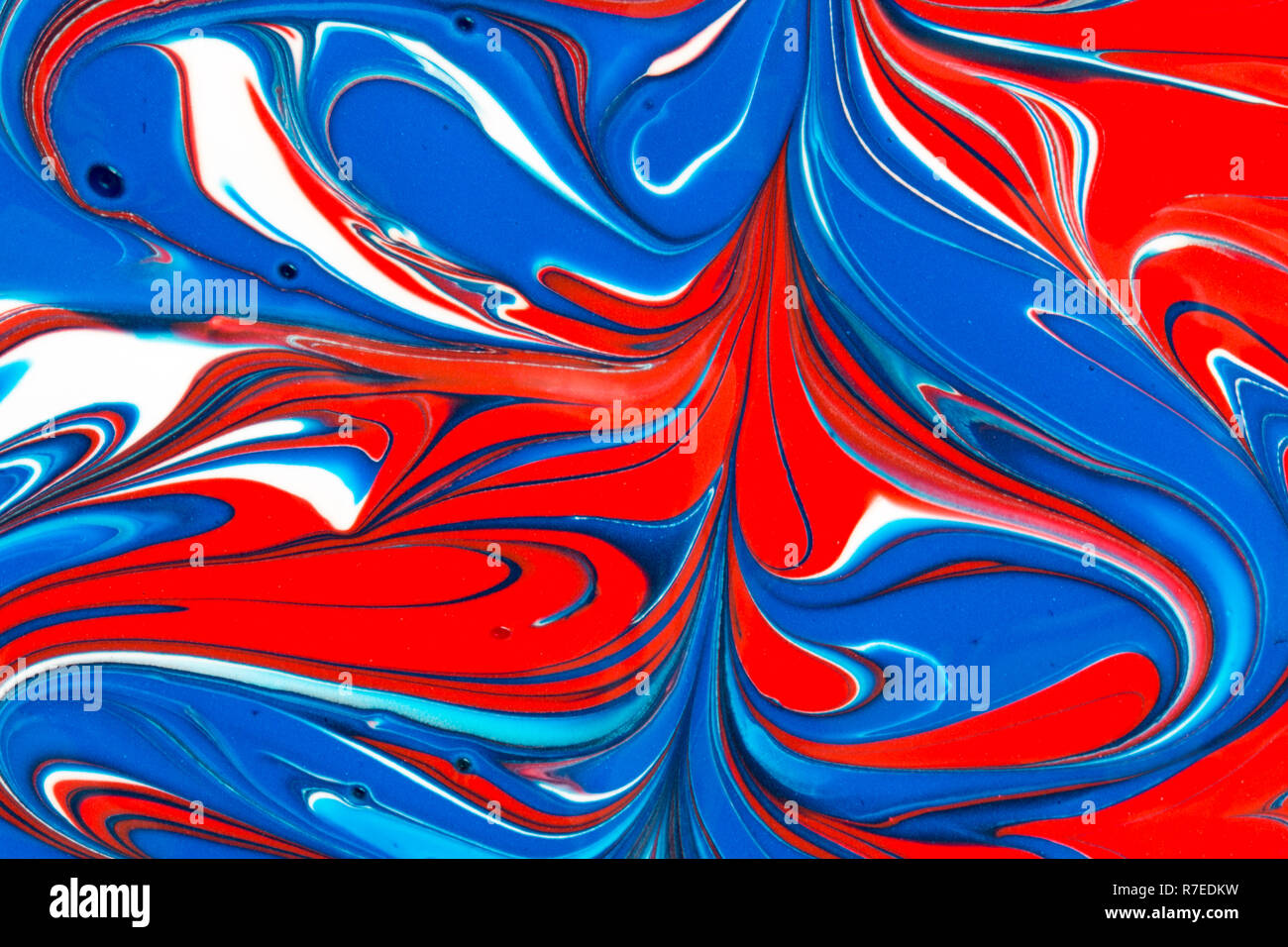 Colourful abstract background of red white and blue liquid paint swirls ...