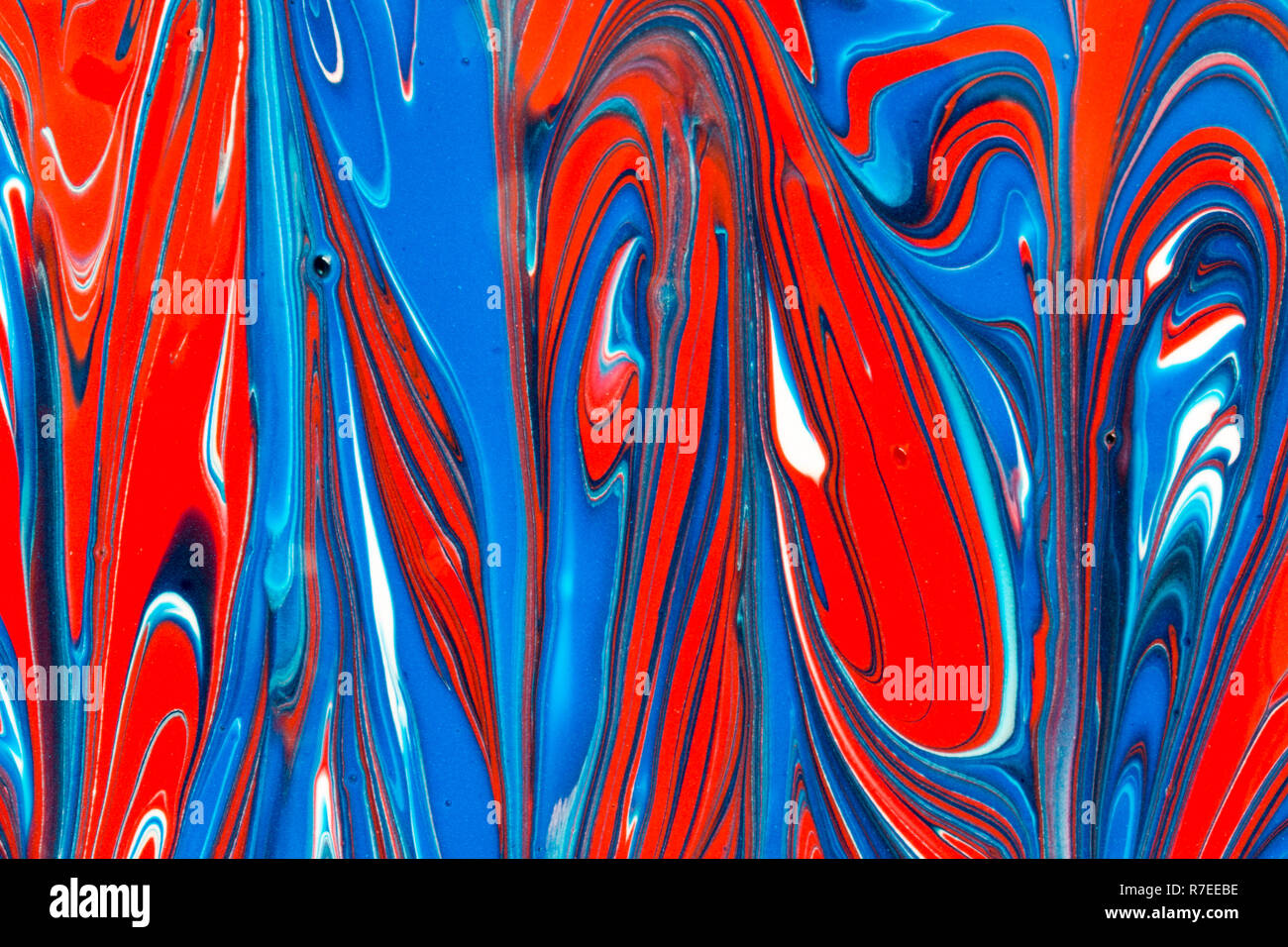 Colourful abstract background of red white and blue liquid paint swirls ...