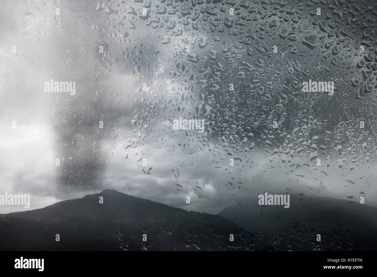 cloudy storm sky over mountains behind rainy window with drops Stock ...