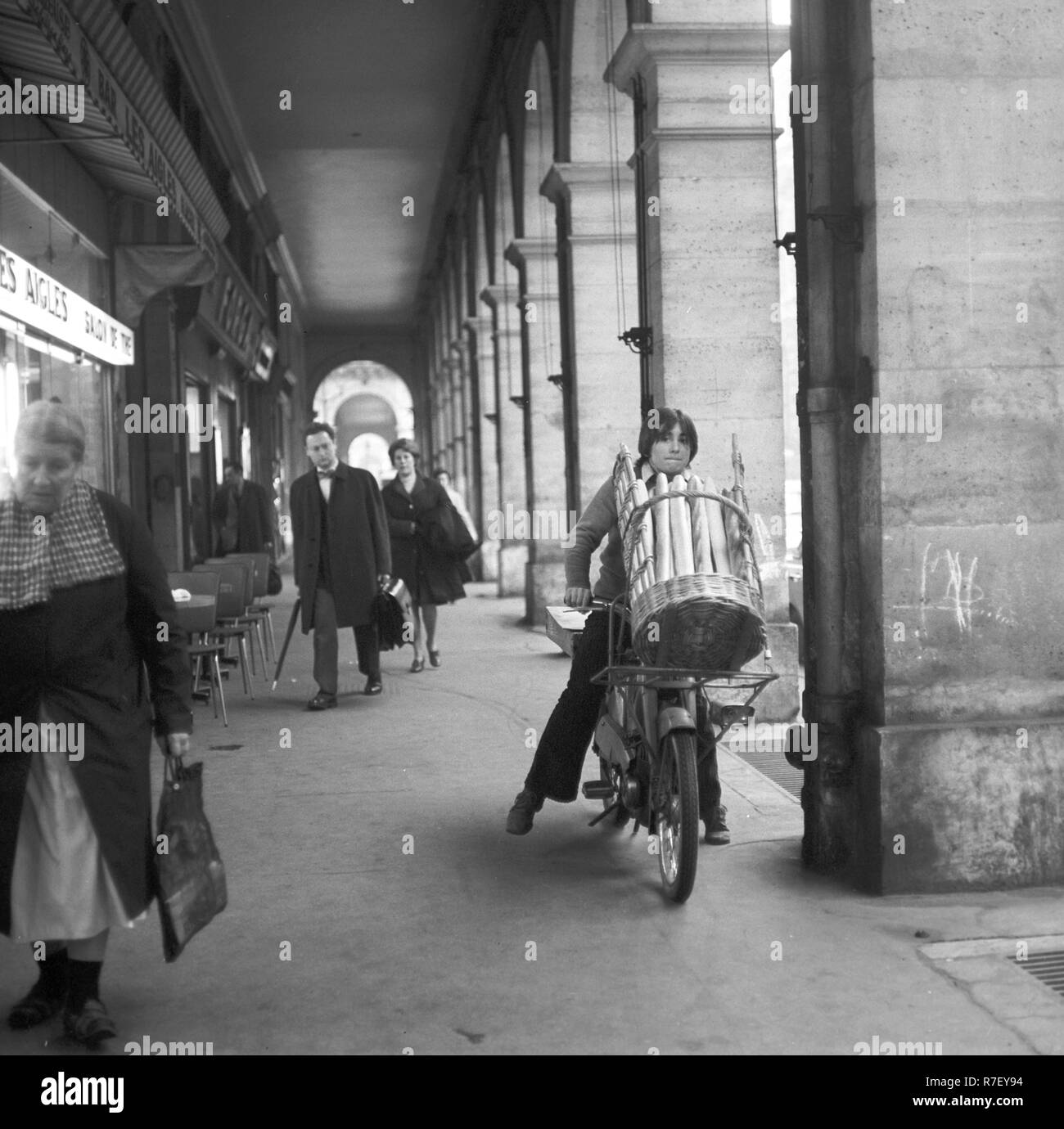 A teenager carries a basket with baguettes on a shopping street in Paris, France, in November 1970. Photo: Wilfried Glienke | usage worldwide Stock Photo