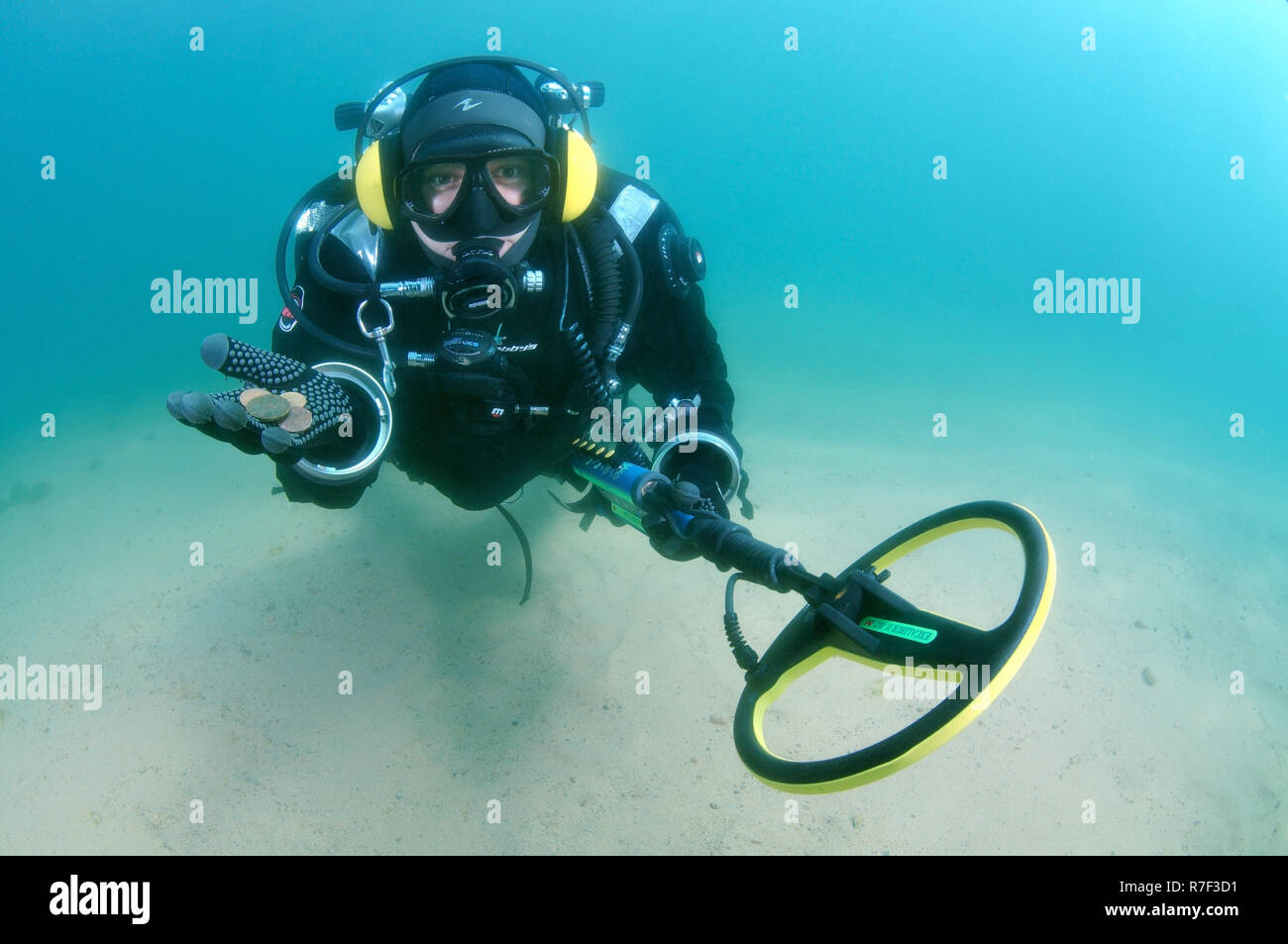 Diver with metal detector displays the ancient coins he found, lake Baikal, Siberia, Russia Stock Photo