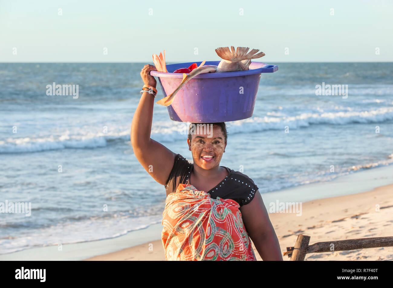 Malagasy woman carrying fish in a tub on her head, Morondava, Toliara province, Madagascar Stock Photo
