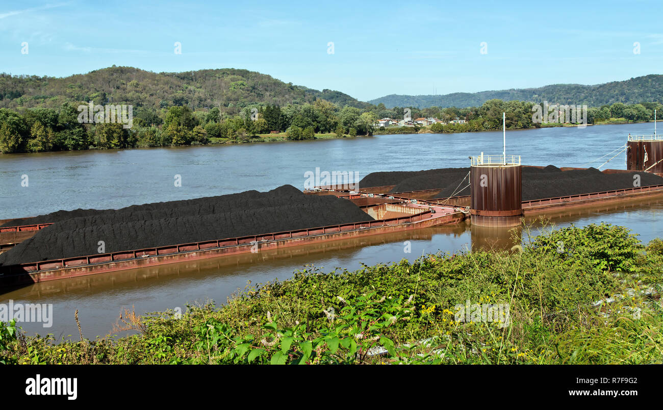 Loaded coal barges awaiting transportation, Ohio River, Ohio state on the opposite shore, near Parkersburg,  West Virginia. Stock Photo