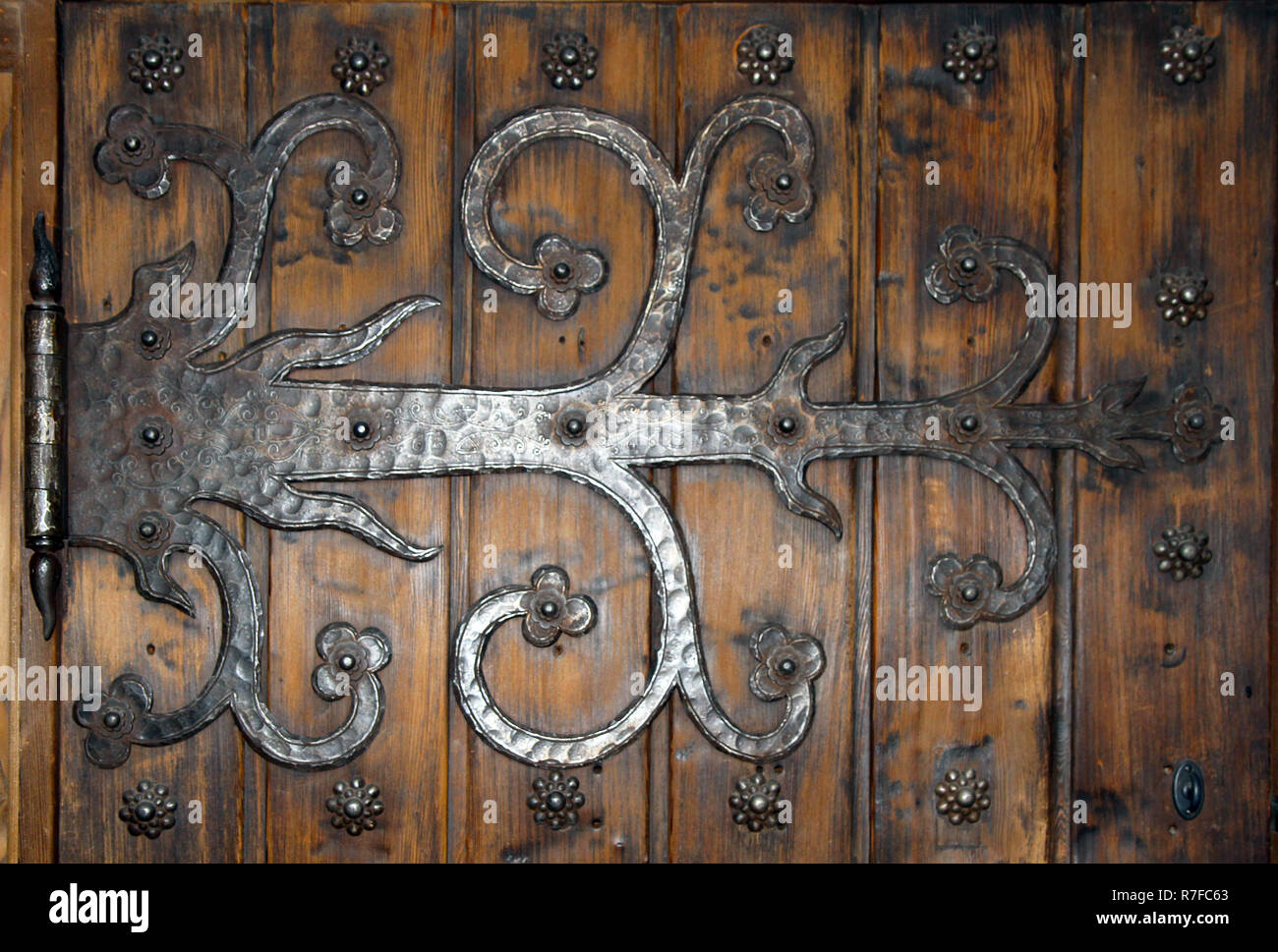 detail of hand crafted ornate iron door hinge Stock Photo