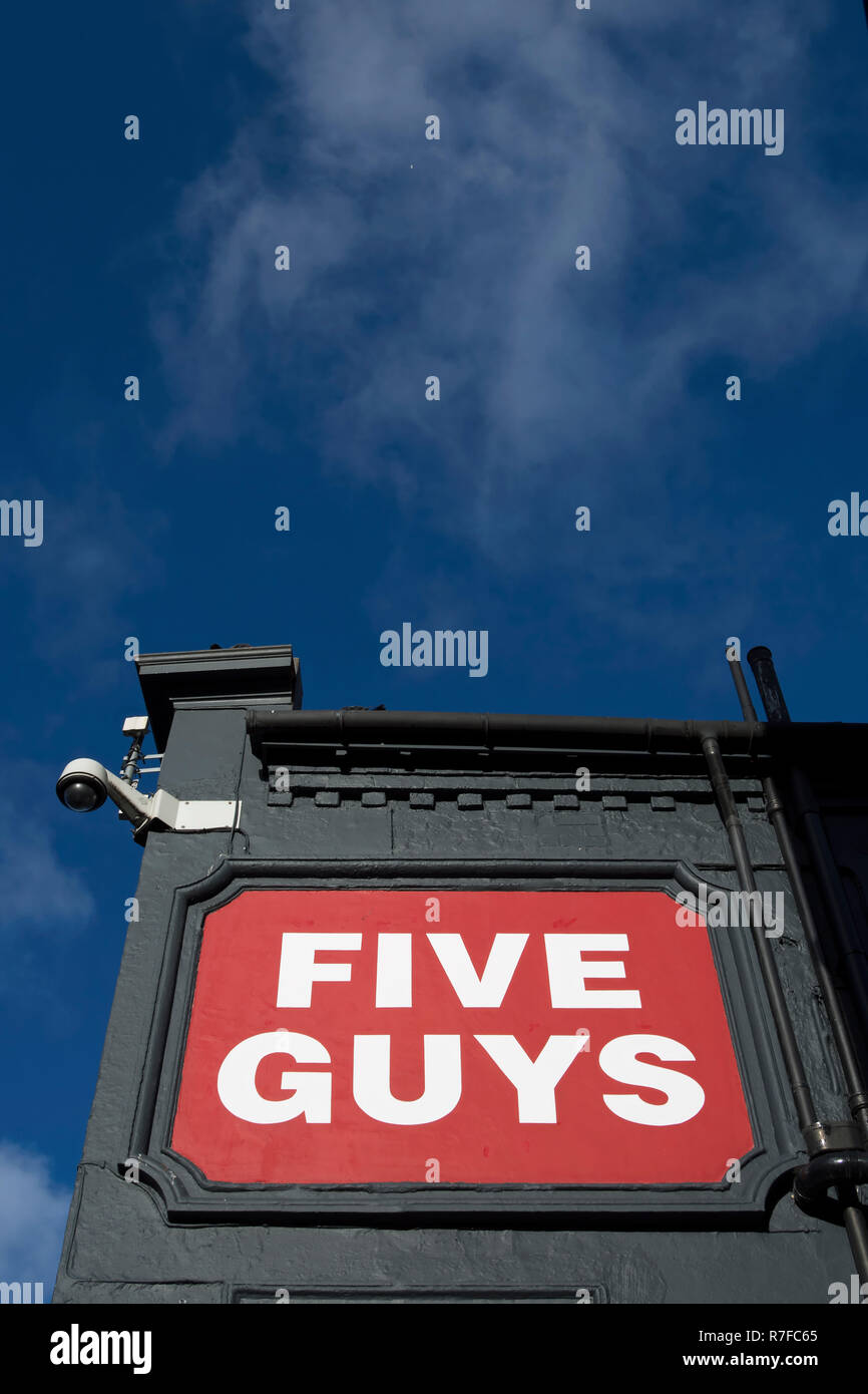 name sign at a branch of the burger restaurant chain five guys, in