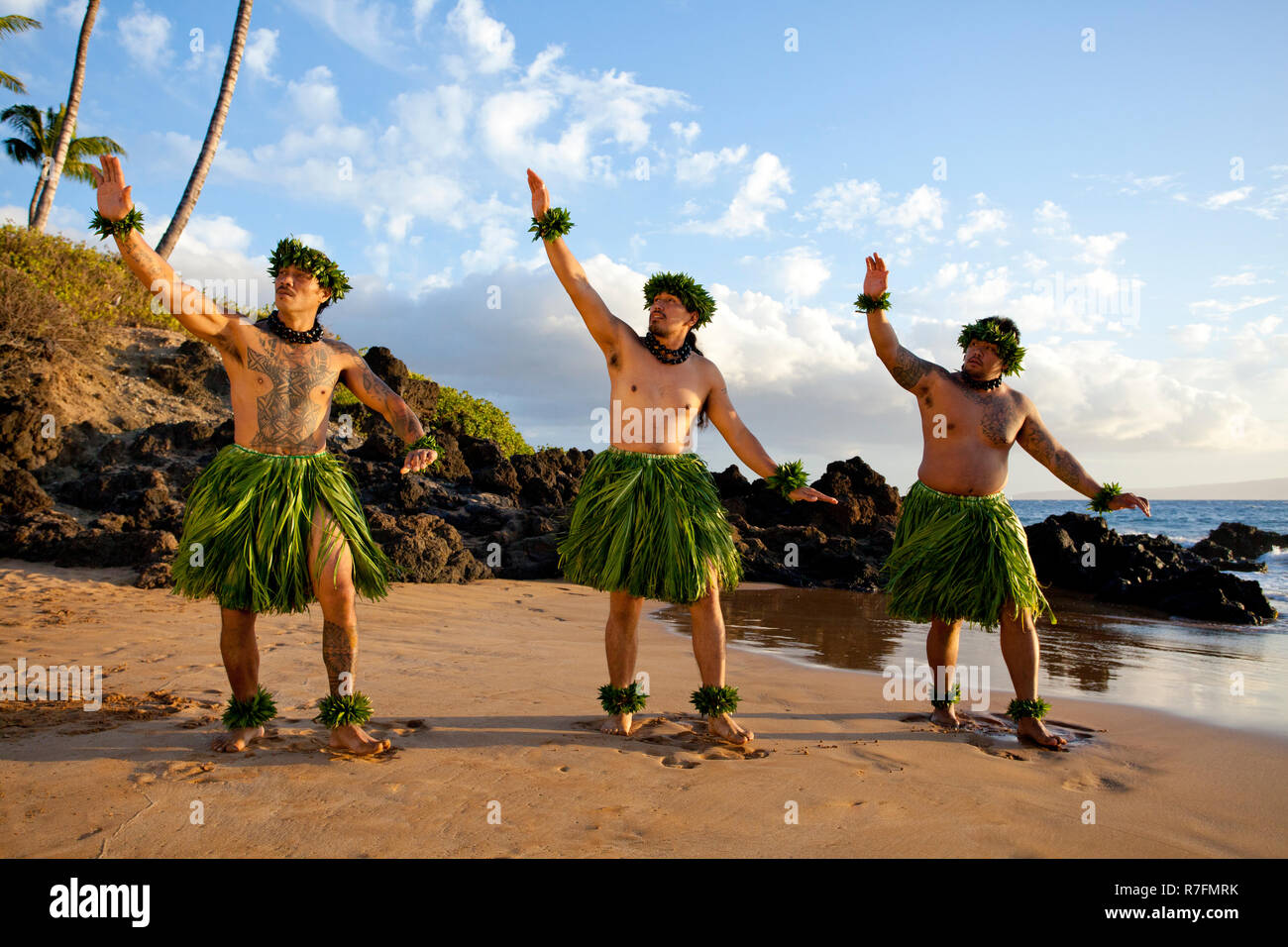 Three male hula dancers at sunset at Maui, Hawaii. Stock Photo