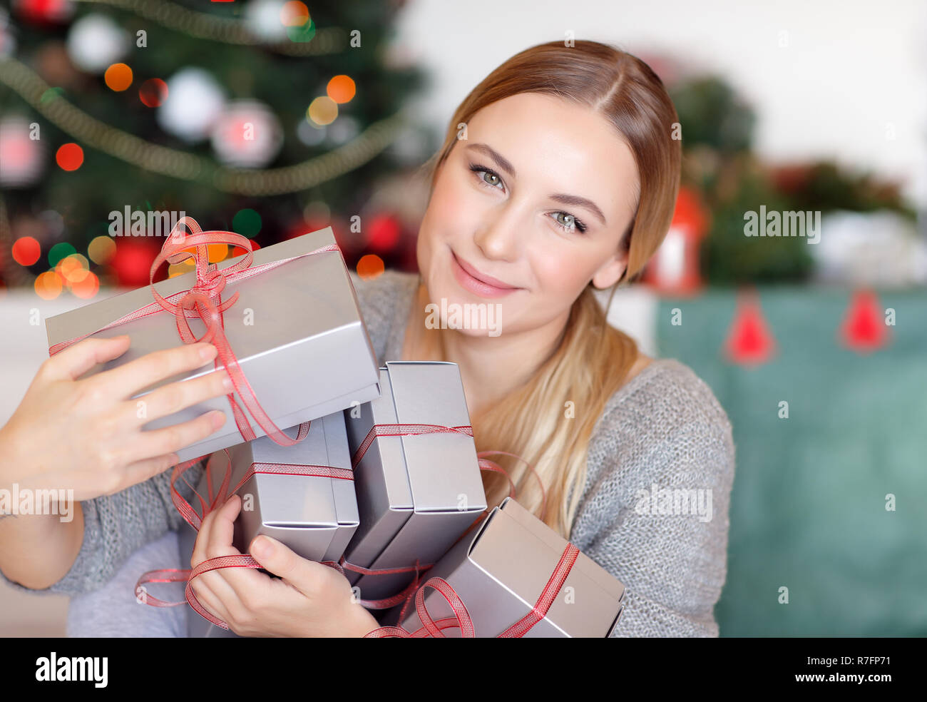 Portrait of a pretty girl with many gift boxes in hands, getting ready ...