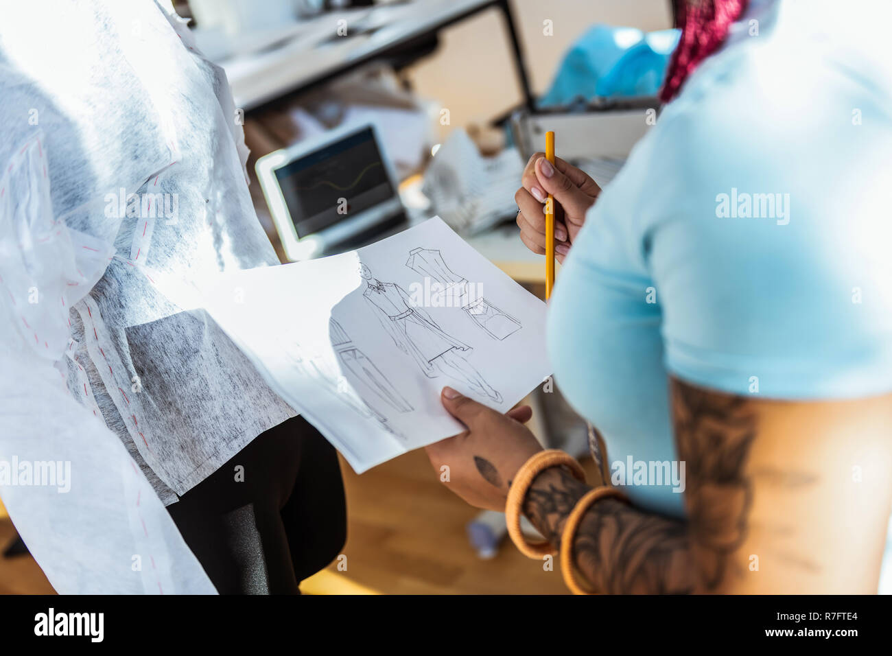 Curvy attractive girl carrying piece of paper with sketches on it Stock Photo