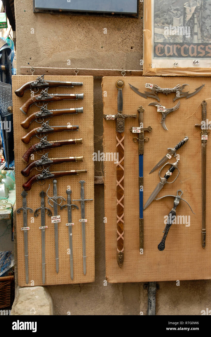 A tourist souvenir shop displaying imitation medieval weapons on sale within the castle walls at Carcassonne in the department of Aude, in the region Stock Photo