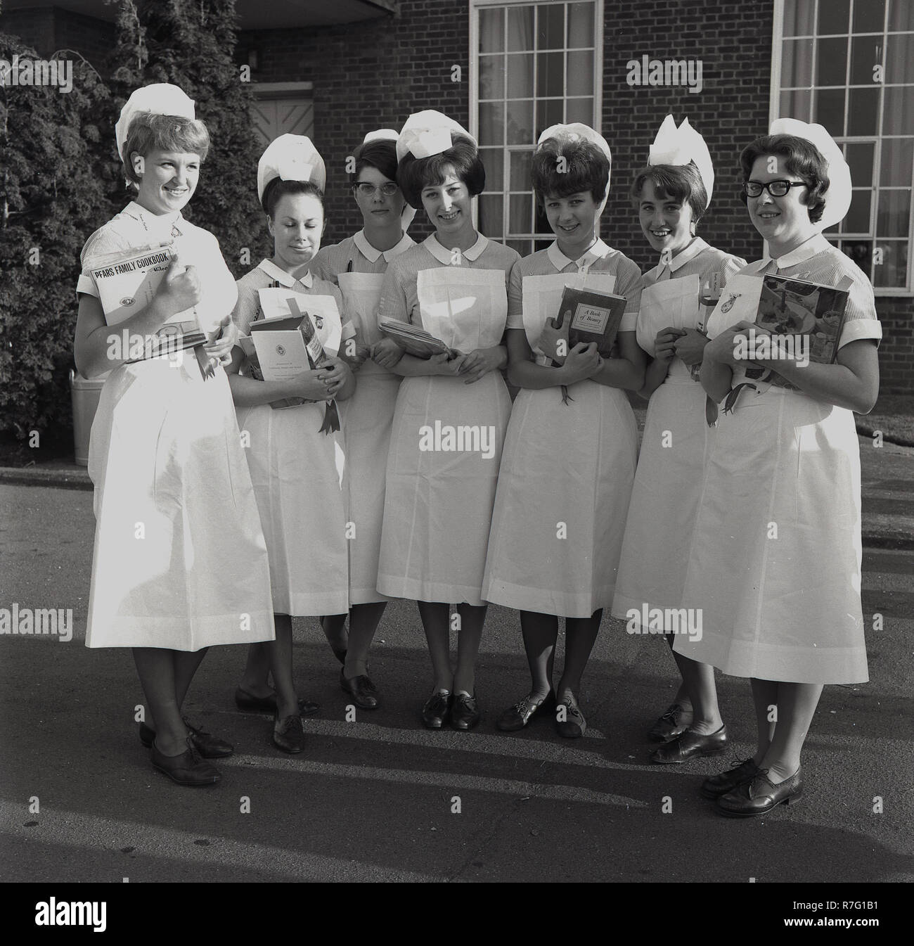 1965, group of British nurses in uniform standing together outside with their nursing certificates and prizes having taken the nursing exams and qualified, England, UK. Stock Photo