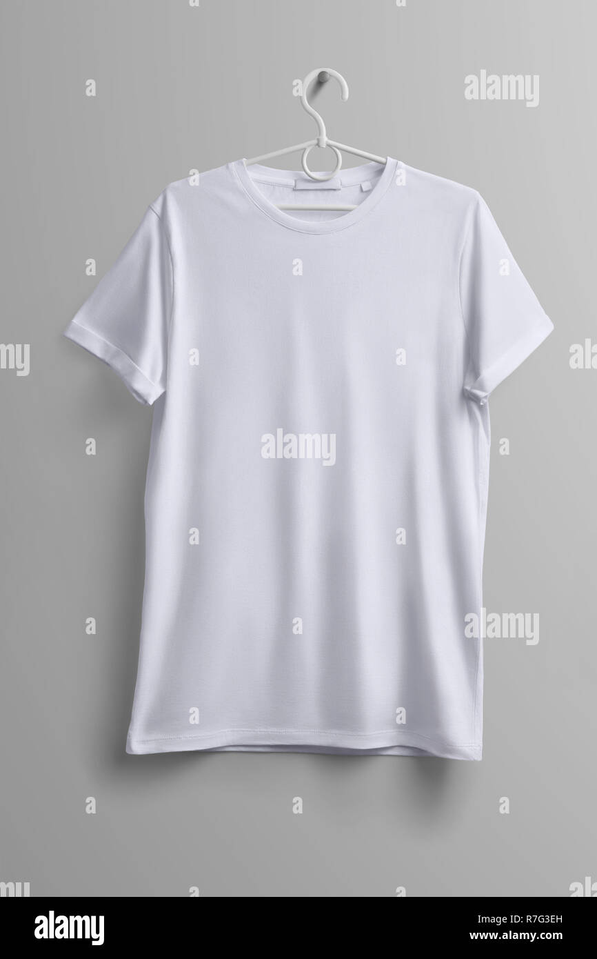 Studio mockup of clothes. White T-shirt hanging on a plastic hanger with shadows on a gray background.  Template  can use for you design. Stock Photo