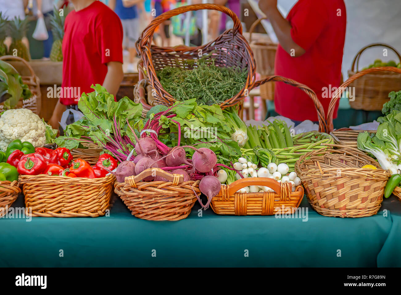 Beautifully detailed baskets filled with vibrant fresh vegetables at the local community farmers market. Stock Photo