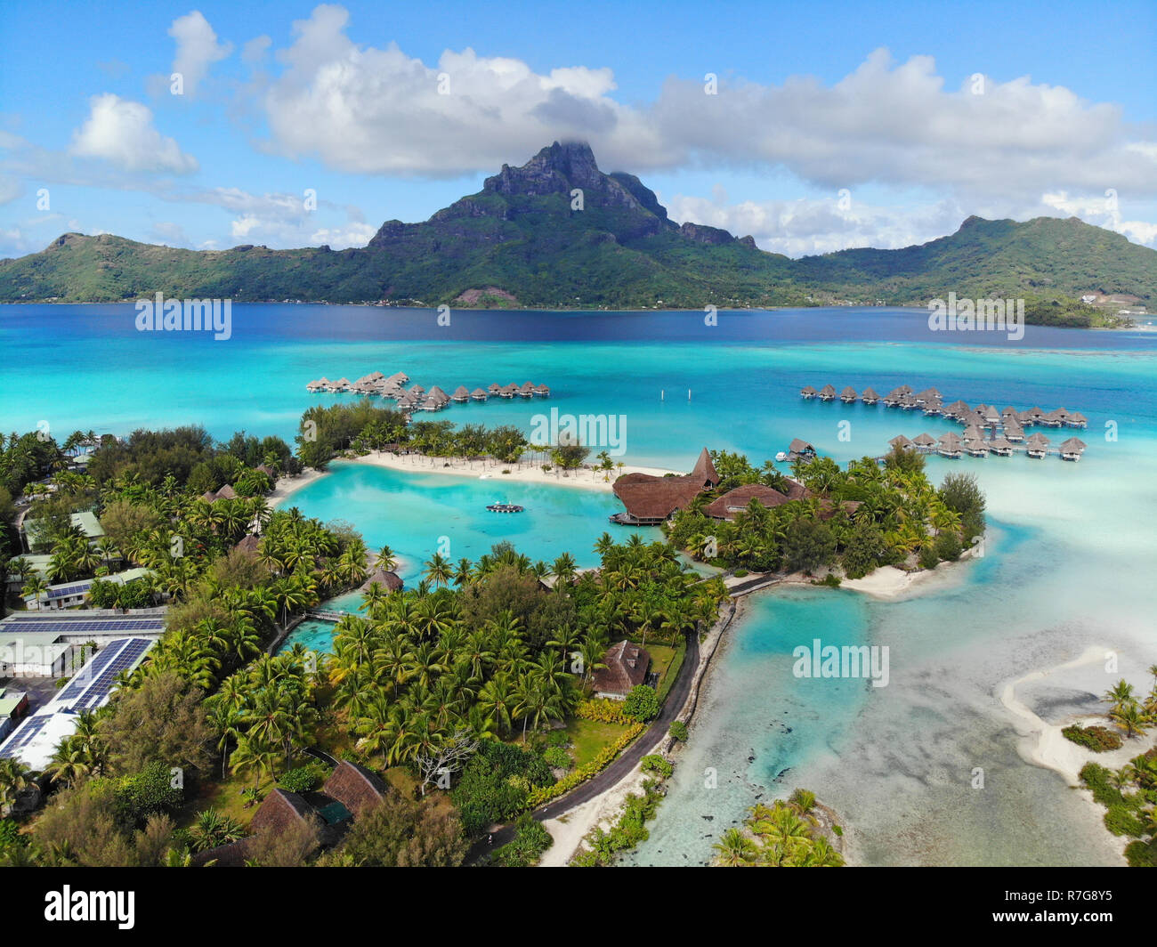 Aerial panoramic landscape view of the island of Bora Bora in French Polynesia with the Mont Otemanu mountain surrounded by a turquoise lagoon, motu a Stock Photo