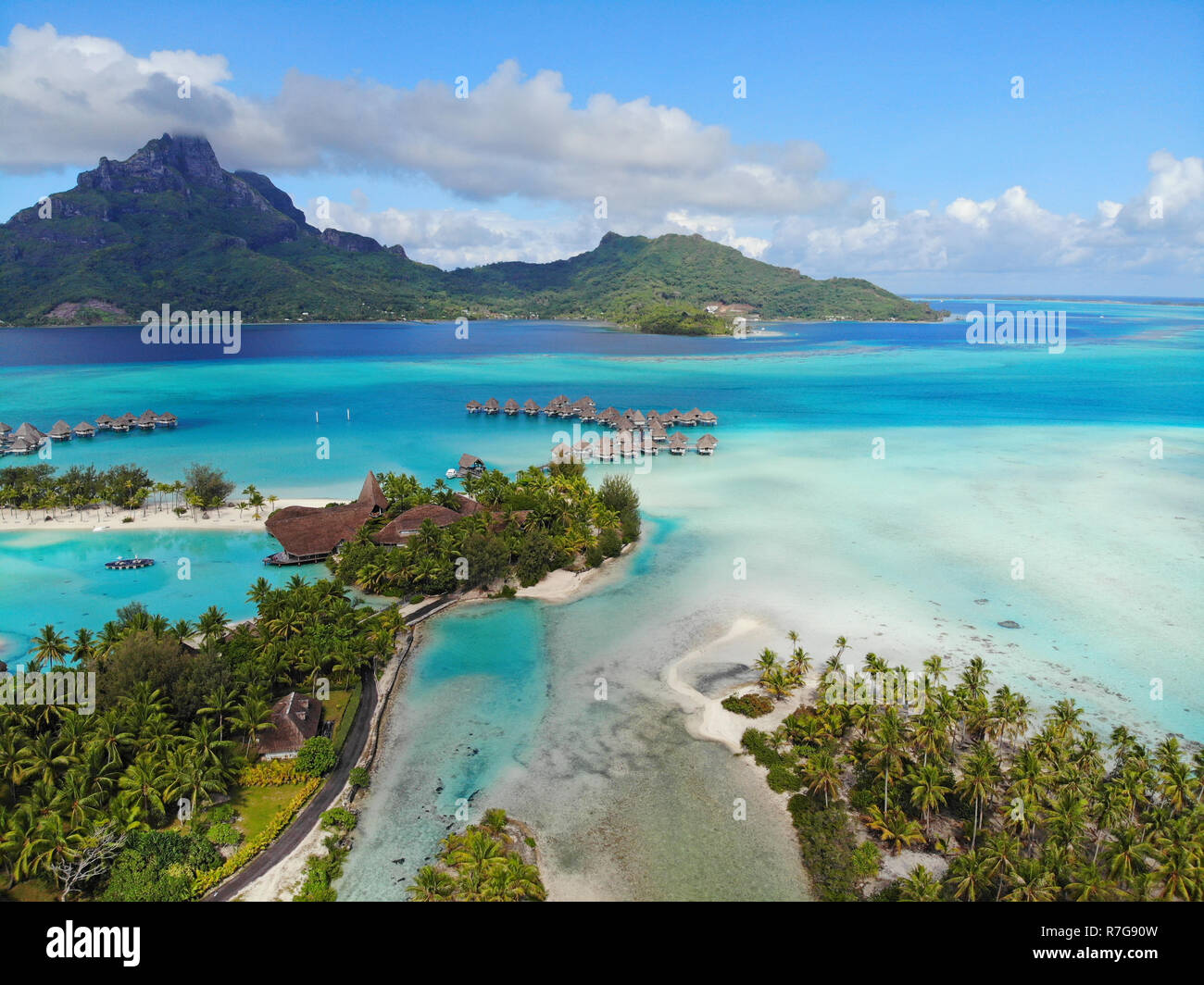 Aerial panoramic landscape view of the island of Bora Bora in French Polynesia with the Mont Otemanu mountain surrounded by a turquoise lagoon, motu a Stock Photo