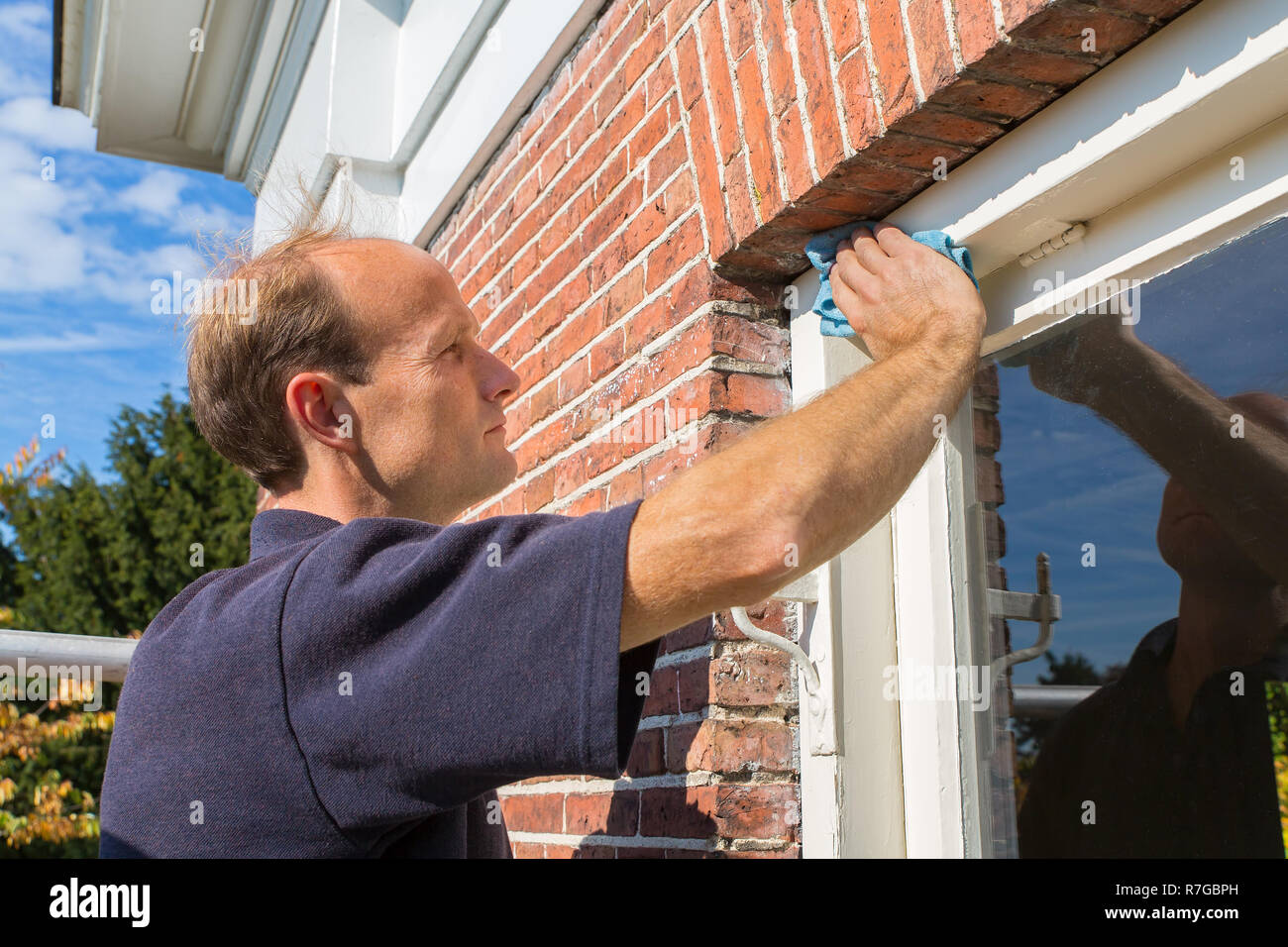 European painter cleans window frame with cloth Stock Photo Alamy
