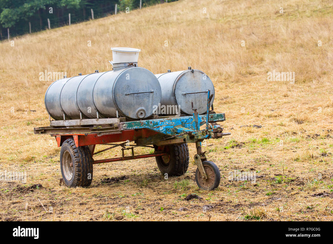 Metal water containers on trailer for cattle in pasture Stock Photo Alamy