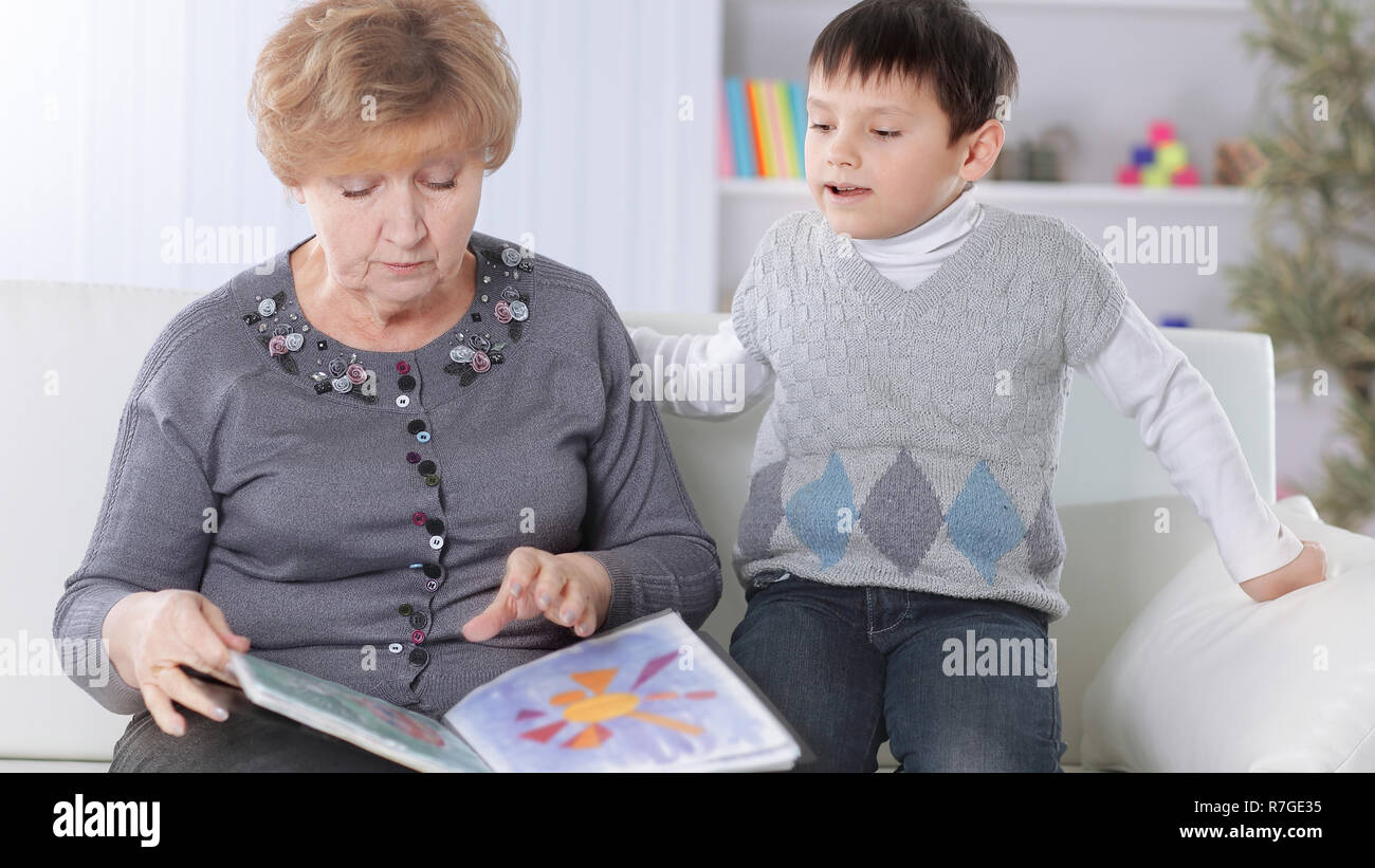 portrait of grandmother and grandson reading a book in the nursery Stock Photo