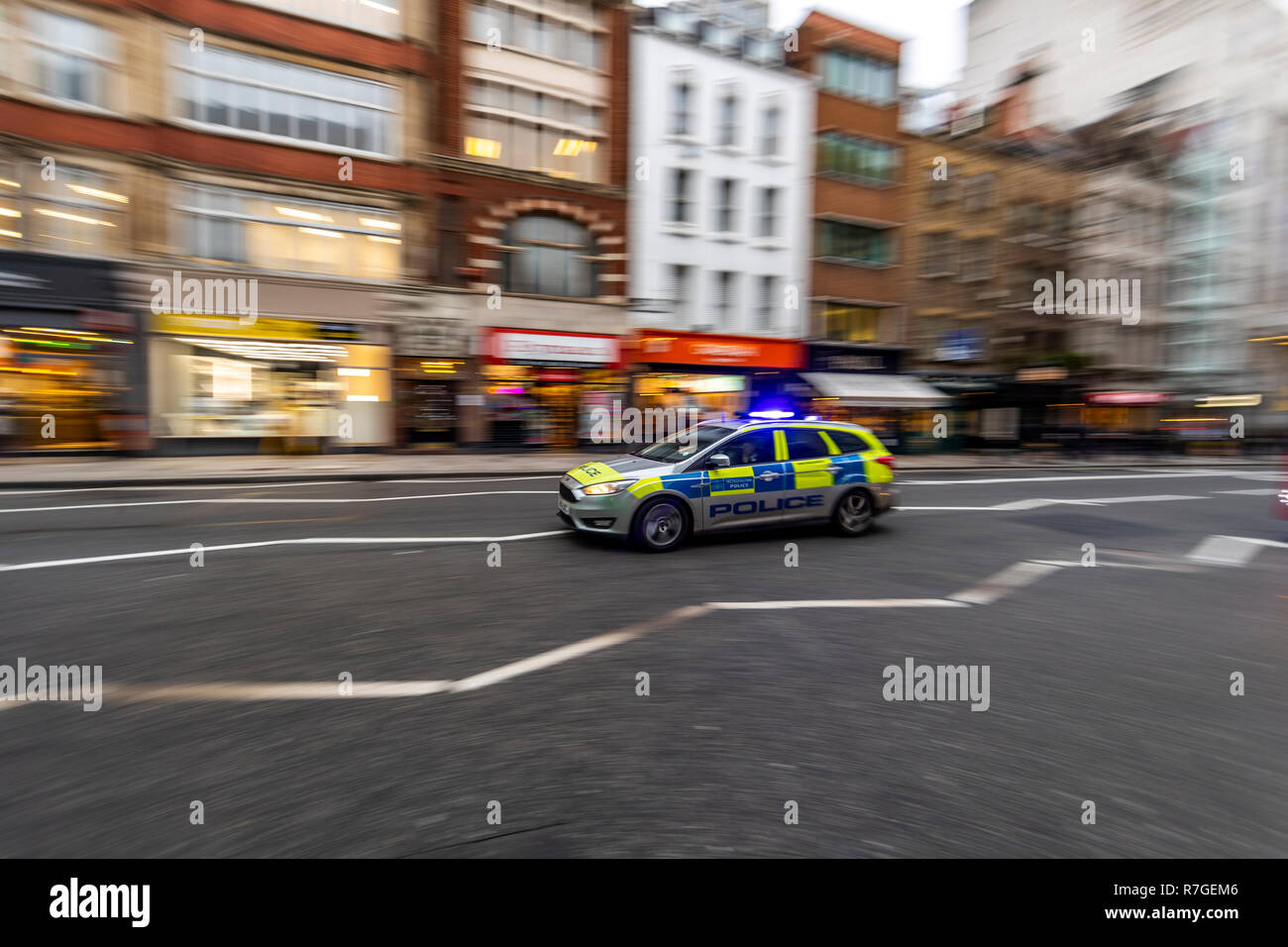 Police car responding with blue lights and sirens, Fleet Street, London