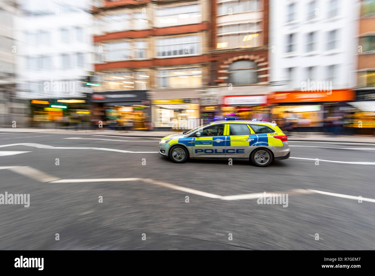Police car responding with blue lights and sirens, Fleet Street, London