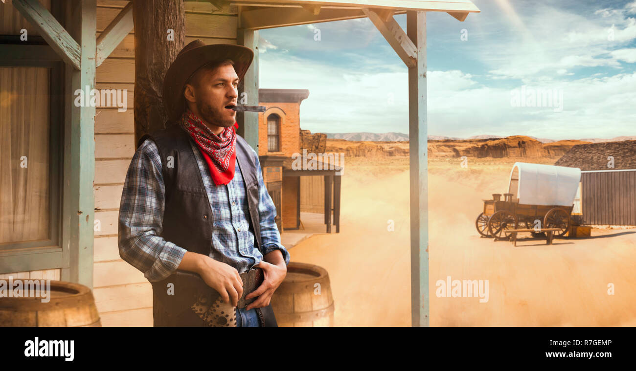 Brutal cowboy smokes a cigar at the saloon entrance, desert valley on