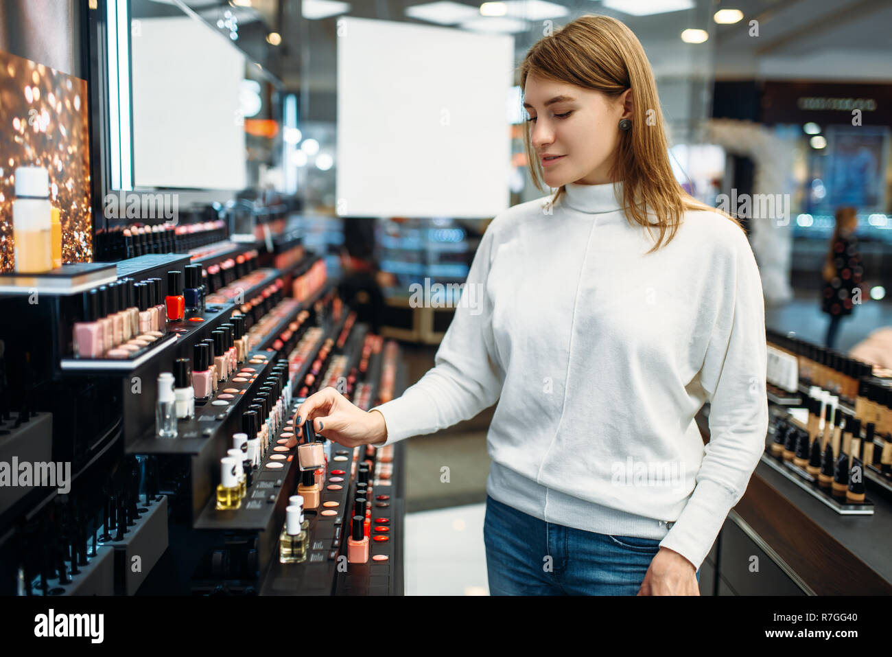 Female customer looking cosmetics in the makeup shop. Nail varnish choosing  in beauty store, make-up salon Stock Photo - Alamy
