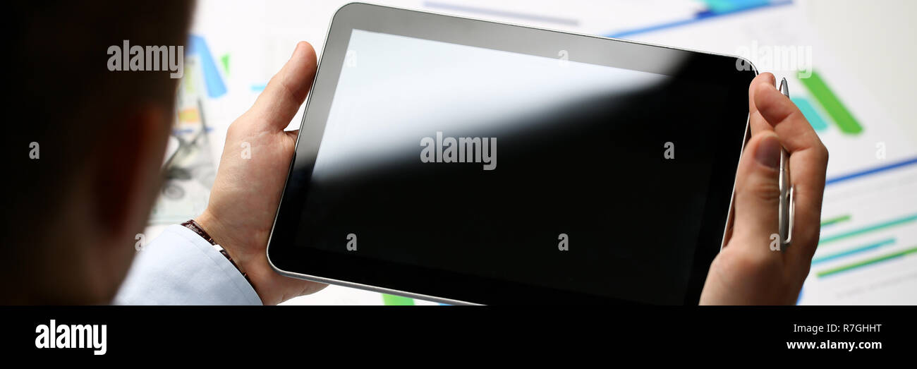 Businessman holds tablet on background Stock Photo