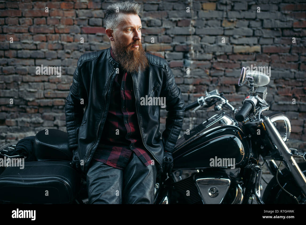 Bearded biker poses on classical chopper, two-wheeled transport ...
