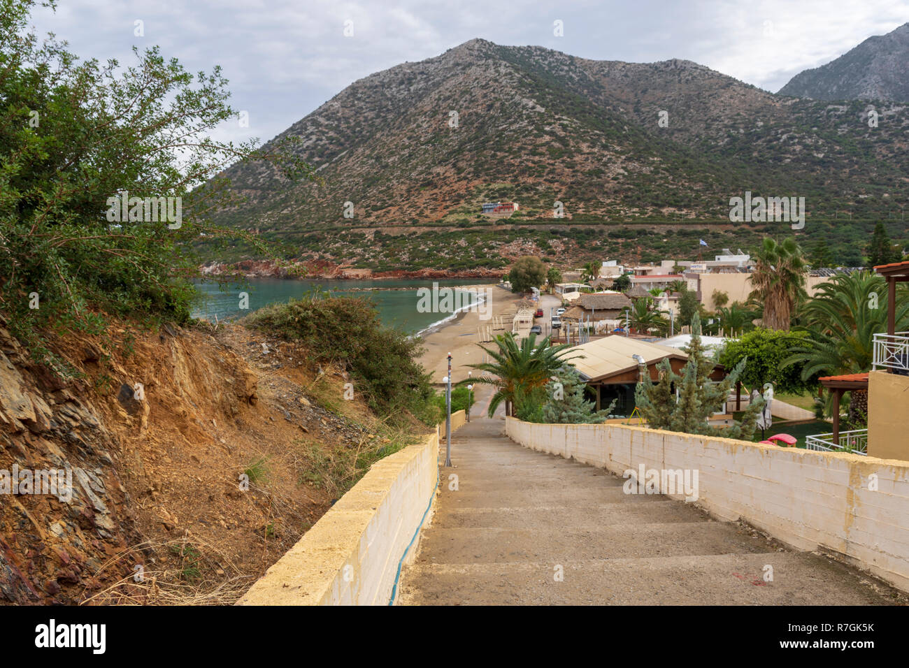 View to the East over the beach in Bali area in Rethymno on Crete Island with a staircase in foreground and a mountain in background. Stock Photo