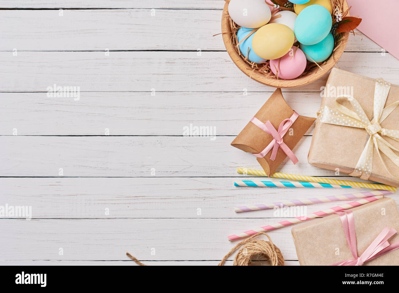 Background with easter eggs, gift boxes and decorations on white, top view with copy space Stock Photo