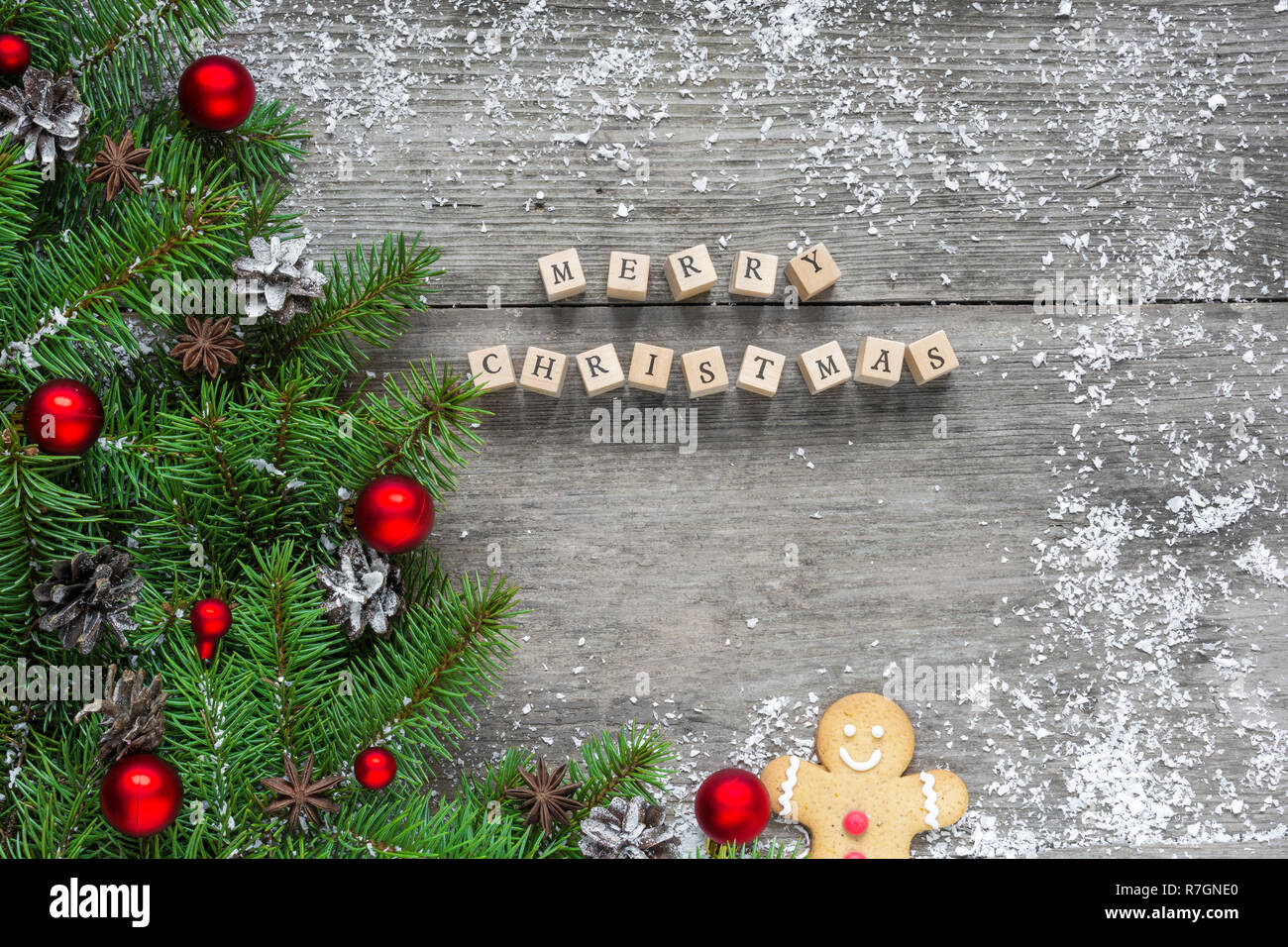 merry christmas inscription with fir branches, festive decorations and pine cones on rustic wooden table. Christmas background. Flat lay. top view Stock Photo