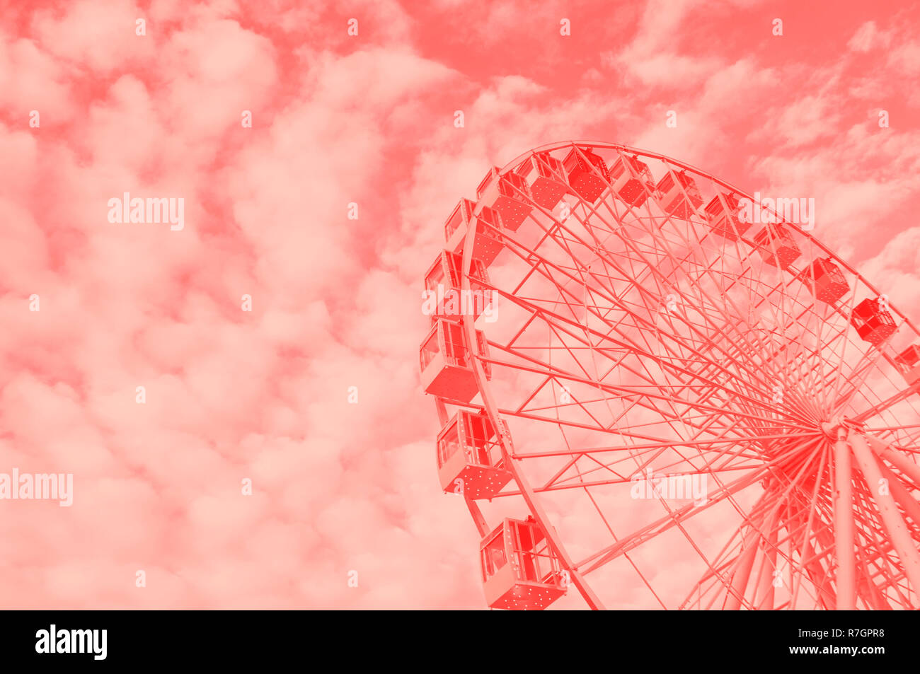 Ferris wheel over blue cloudy sky in a fun park. Stock Photo