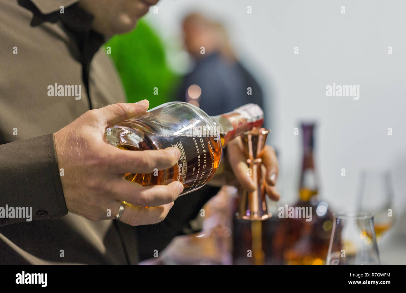 KIEV, UKRAINE - OCTOBER 20, 2018: Man sommelier pours Woodford bourbon whisky at booth of 4th Ukrainian Whisky Dram Festival organized by Good Wine co Stock Photo