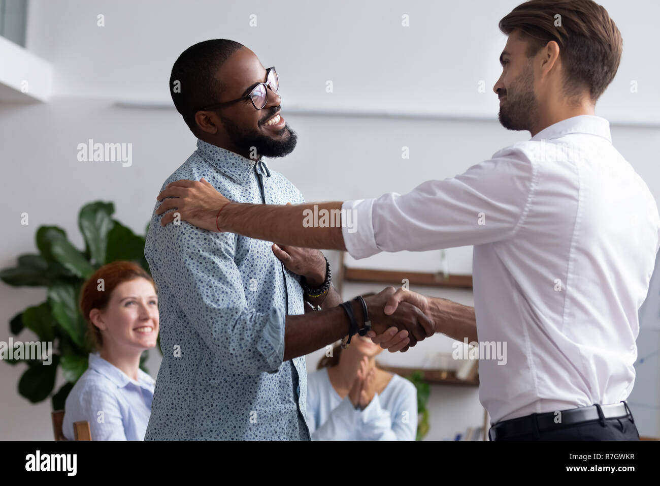Company boss congratulating handshaking with successful employee Stock Photo