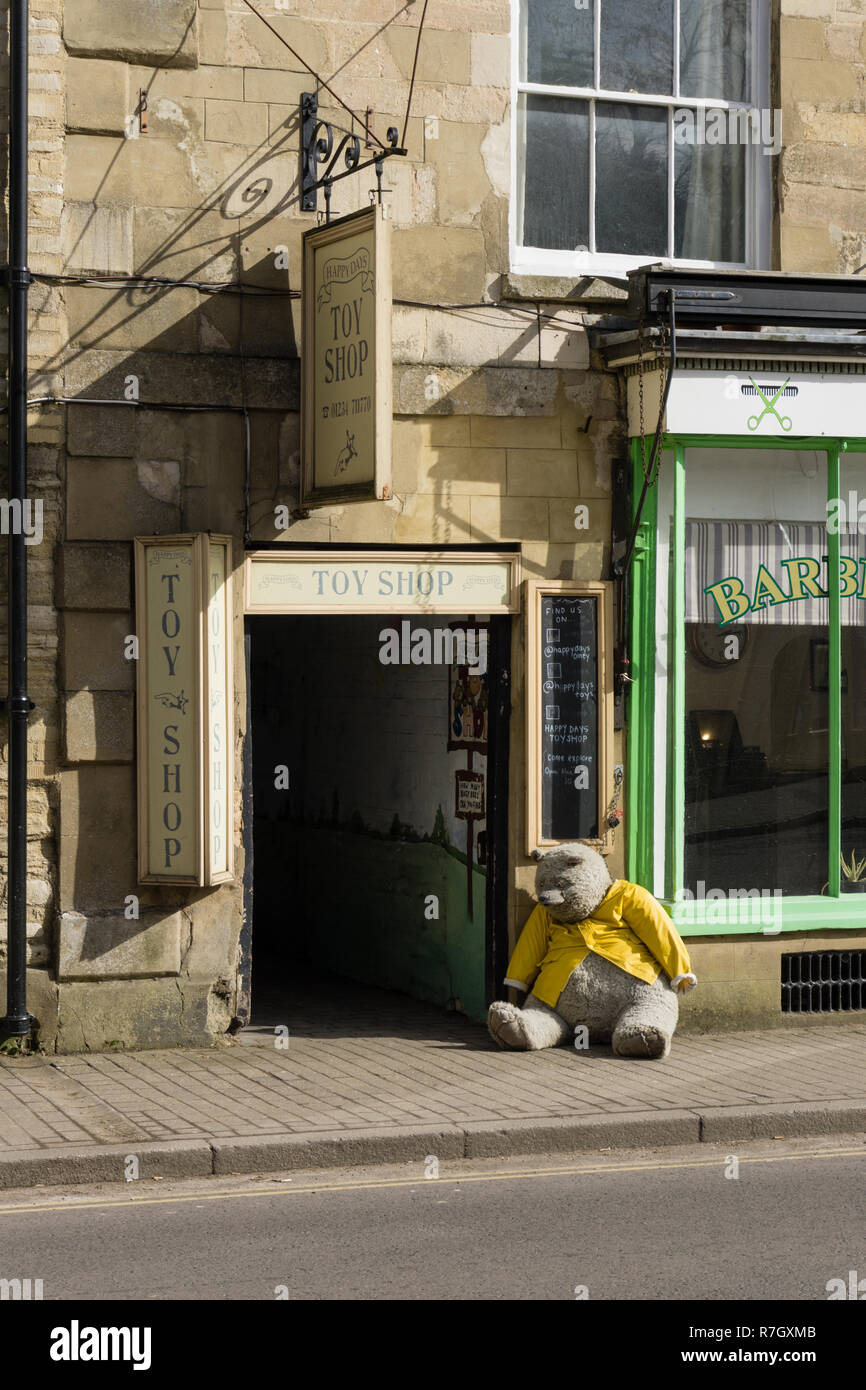 Entrance to the Happy Days Toy Shop with a giant stuffed bear outside; High Street, Olney, UK Stock Photo