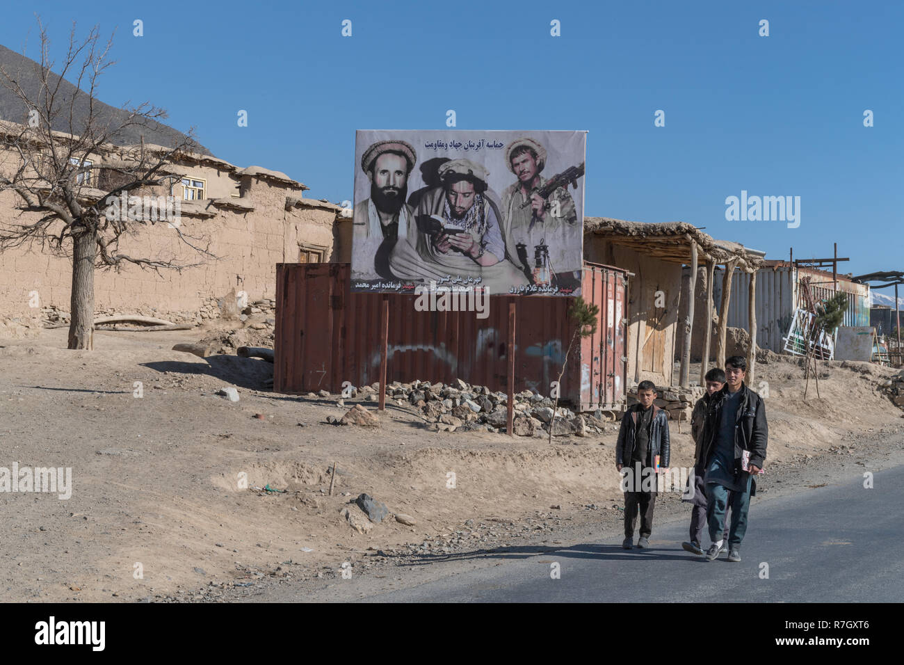 Young Men Walking Past Commander Massoud's Portrait, Panjshir Valley, Panjshir Province, Afghanistan Stock Photo