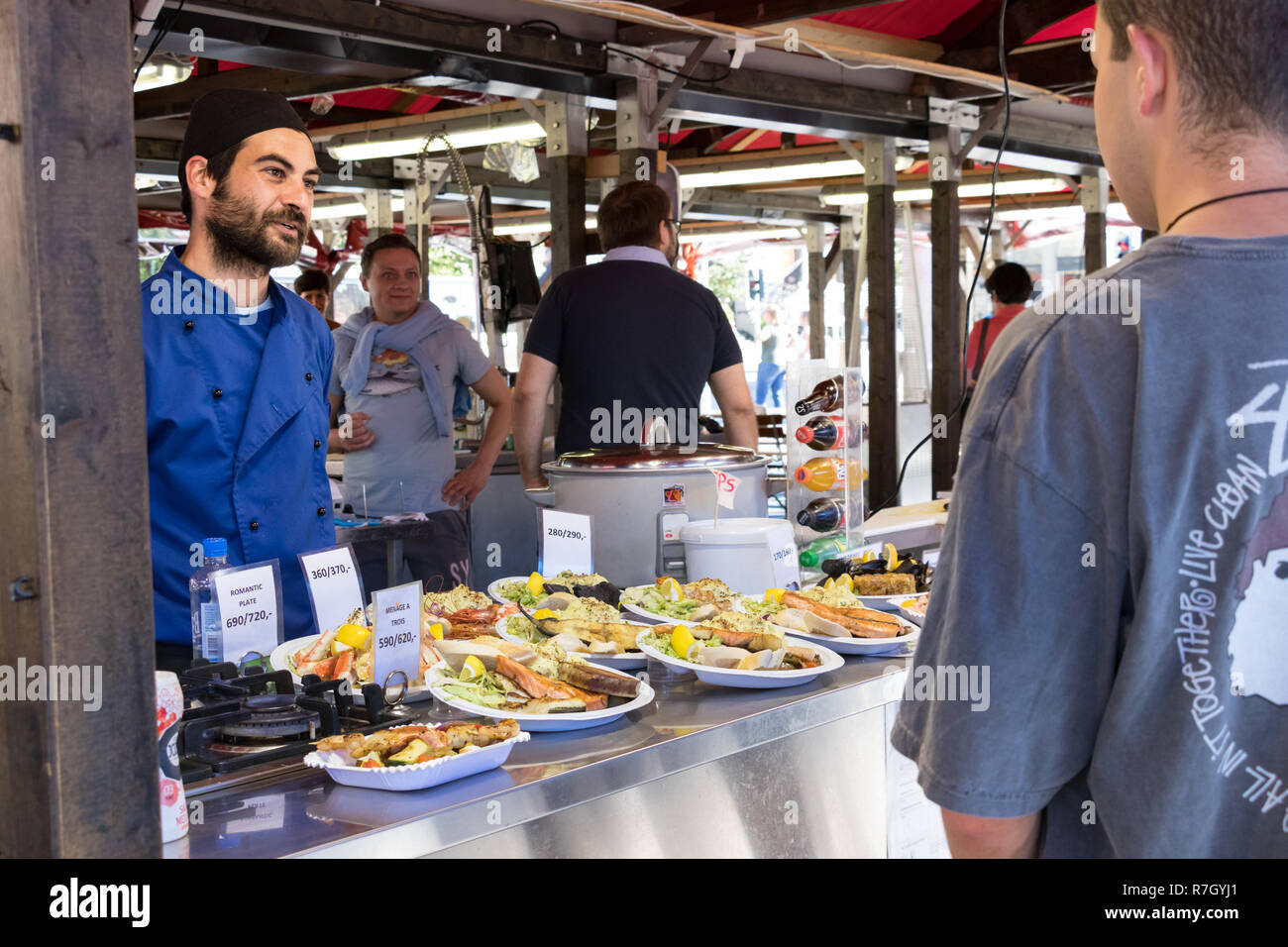 Bergen, Norway July 26th, 2018 A male cook selling fried fish food
