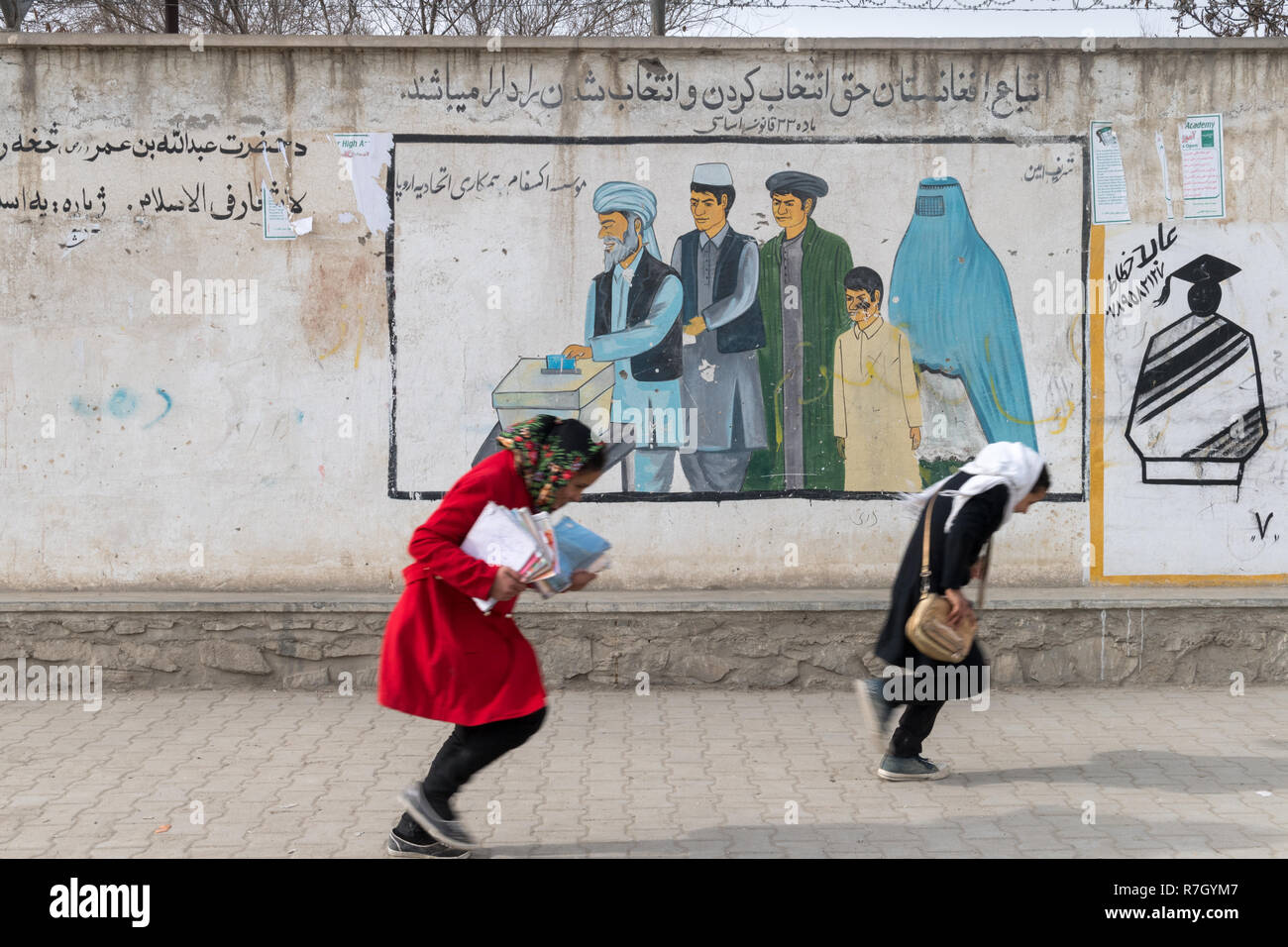 Girls Walking Back Home After School With A Mural Painting Promoting Voting For Men and Women, Kabul, Kabul Province, Afghanistan Stock Photo