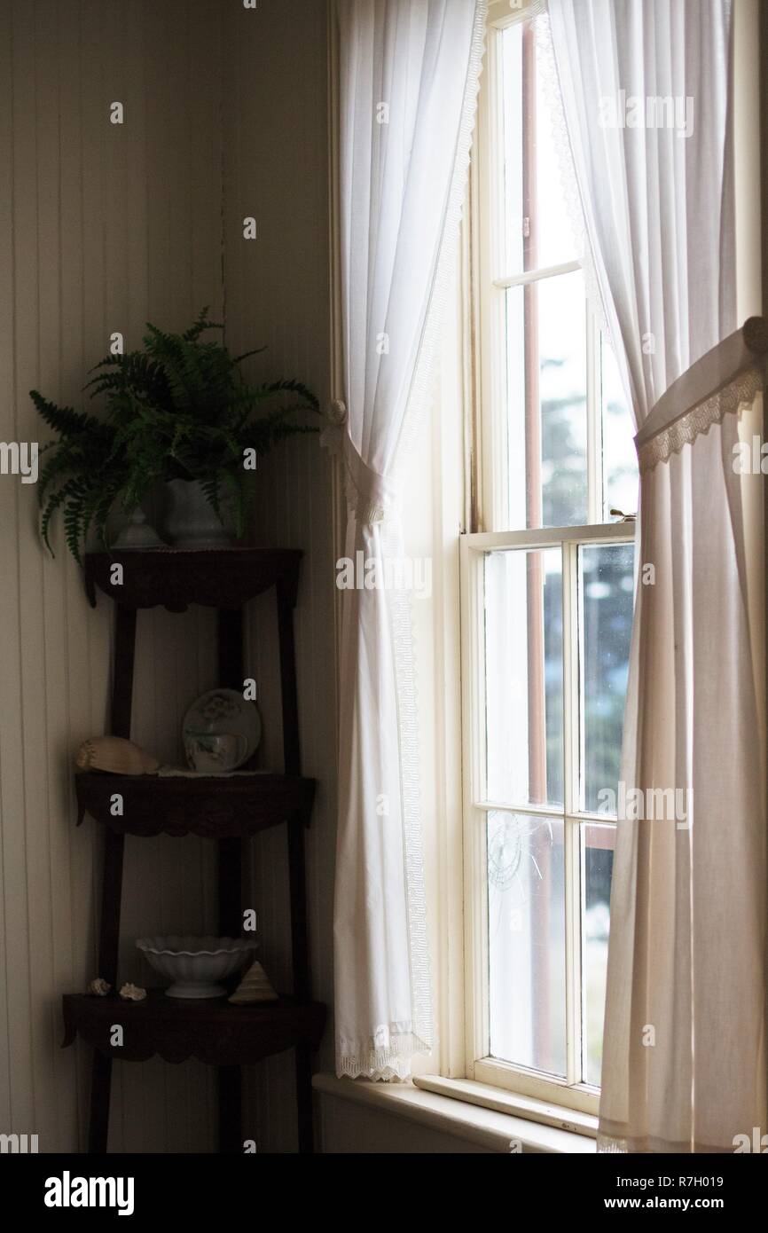 A Window With Sheer White Curtains Inside The Yaquina Bay